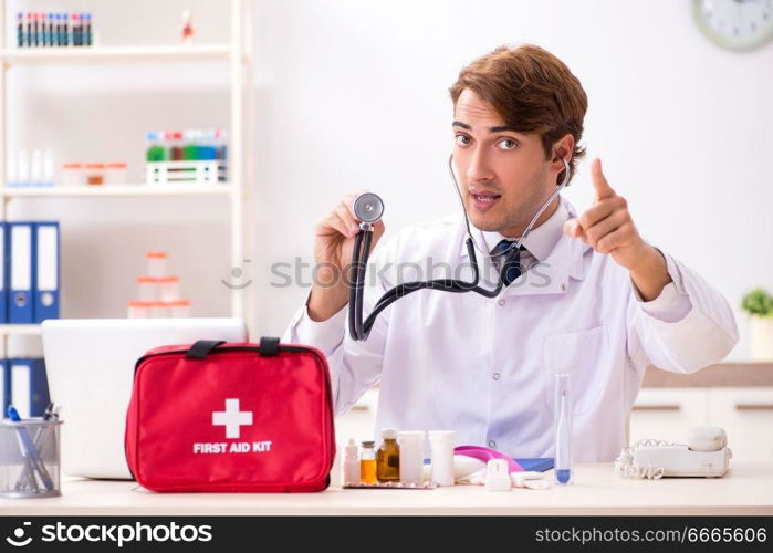 Young doctor with first aid kit in hospital