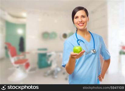 Young doctor with green apple on medical office