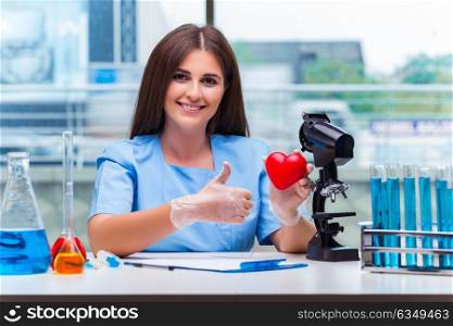 Young doctor with red heart in lab