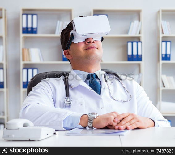 Young doctor with vr virtual reality headset working in the office. Young doctor with vr virtual reality headset working in the offi