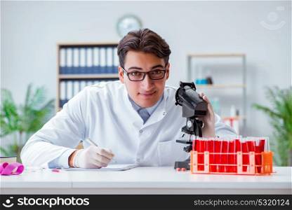Young doctor working in the lab with microscope