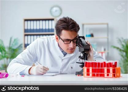Young doctor working in the lab with microscope