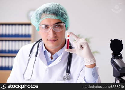 Young doctor working in the lab with microscope