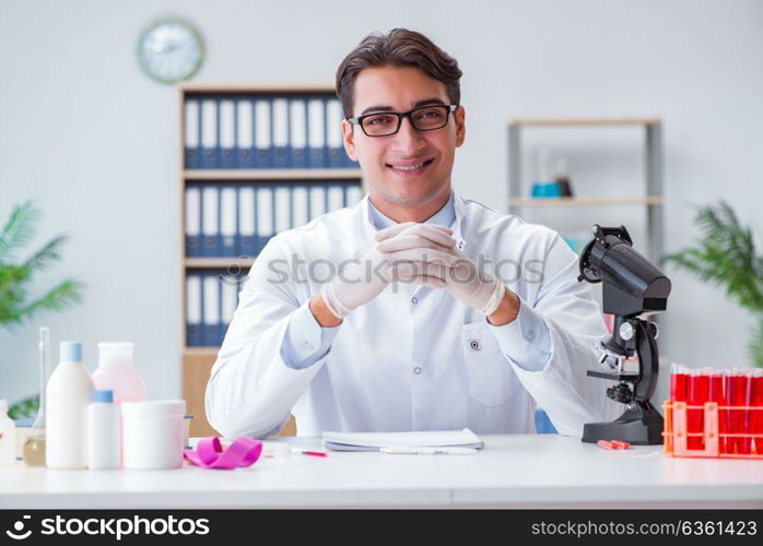 Young doctor working in the lab with microscope