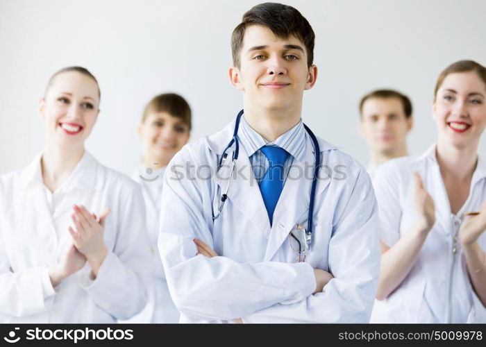 Young doctor. Young doctor in uniform and colleagues at background