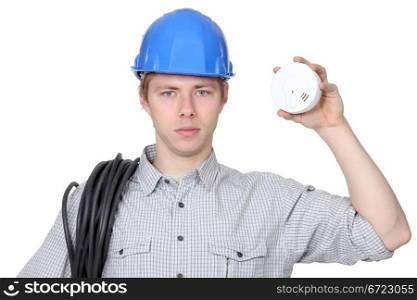 Young electrician holding smoke alarm