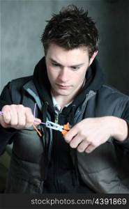 young electrician using pliers