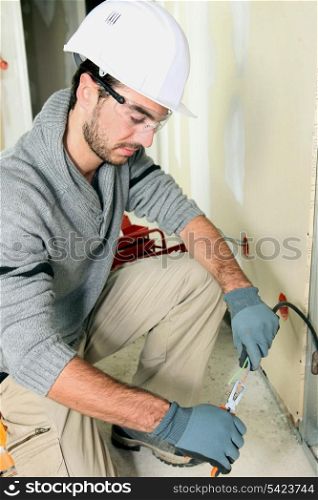 young electrician using pliers