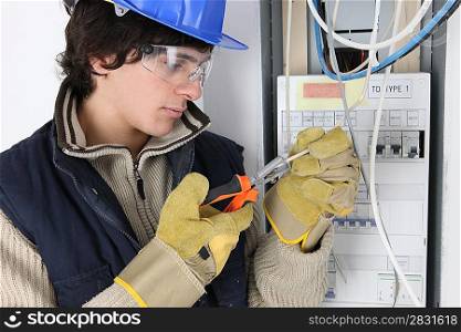 Young electrician working on a fuse box