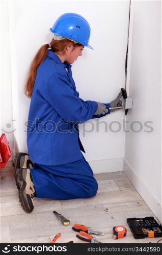 Young electrician working on power outlet