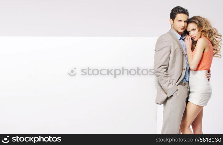 Young elegant couple with the huge white board