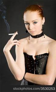 young elegant girl with a cigaret on a black background