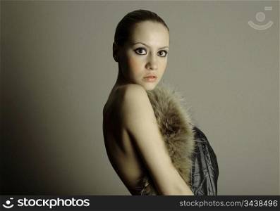 young elegant girl with fur coat. Studio portrait
