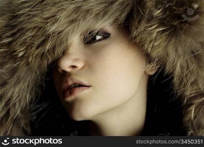 young elegant girl with fur coat. Studio portrait