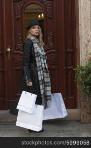 young elegant lady , near her luxury door home , she is coming back from shopping of winter sale , taking some shopping bags