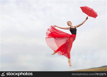 Young Elegant Woman Flying in the Cloudy Sky in the Black Gymnastics Leotard , Red Long Skirt with Red Polka Dot Umbrella