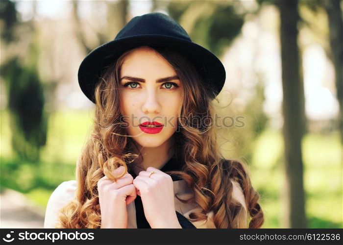 Young elegant woman in stylish clothes. Model with red lips in hipster cloth and vintage black hat in sunglasses. Fashion shot. Modern youth lifestyle concept.