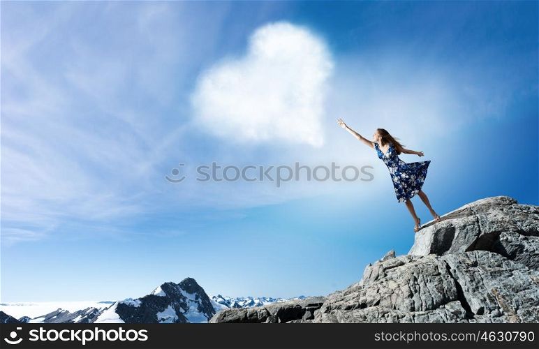 Young elegant woman trying to reach sky