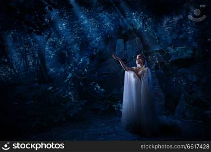 Young elf girl in night forest