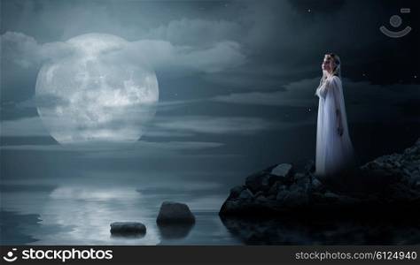 Young elven girl at night sea shore