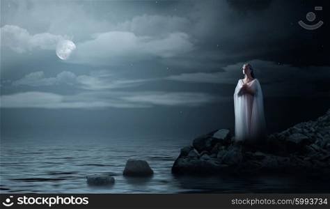 Young elven girl on night sea coast