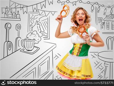 Young emotional sexy Oktoberfest woman wearing a traditional Bavarian dress dirndl holding two pretzels on sketchy bar counter background.