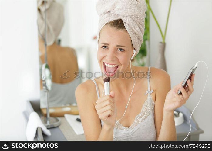 young emotional woman singing in bathroom after shower