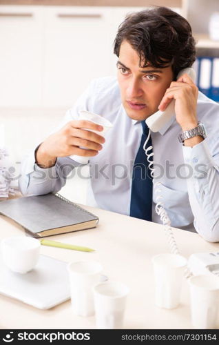 Young employee addicted to coffee