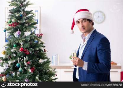Young employee celebrating christmas at workplace