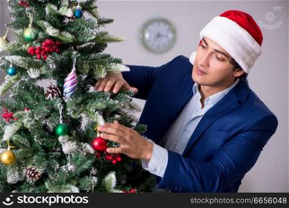 Young employee celebrating christmas at workplace