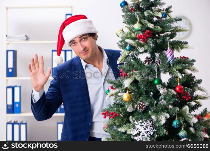 Young employee celebrating christmas at workplace