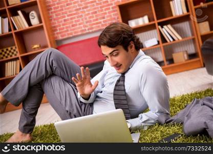 Young employee lying on the floor at office 