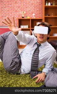Young employee with virtual glasses during break in the office 