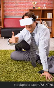 Young employee with virtual glasses during break in the office 