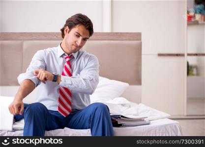 Young employee working at home sitting on the bed 
