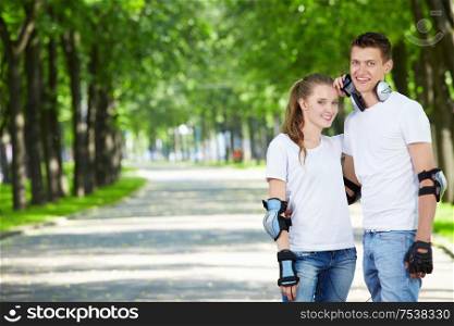 Young enamoured couple on rollers in park