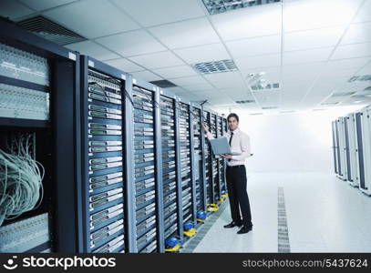 young engeneer business man with thin modern aluminium laptop in network server room