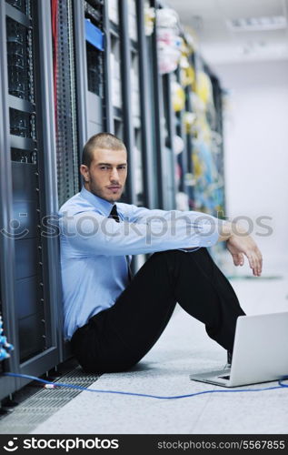 young engeneer business man with thin modern aluminium laptop in network server room