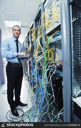 young engeneer business man with thin modern aluminium laptop in network server room