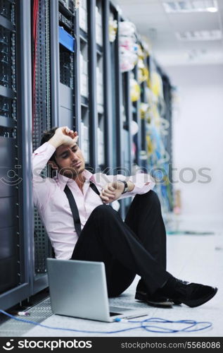 young engeneer business man with thin modern aluminium laptop in network server room