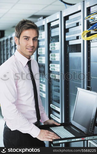 young engeneer business man with thin modern aluminium laptop in network server room