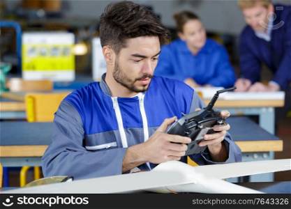 young engineer at desk with remote control aircraft