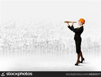 Young engineer. Image of young woman looking into tube. Construction concept