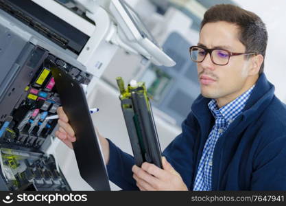 young engineer in the lab adjusting a 3d printers components