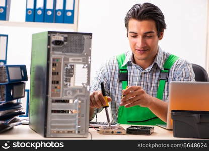 Young engineer repairing broken computer at the office 