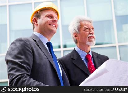 young engineer showing something to his partner at building site