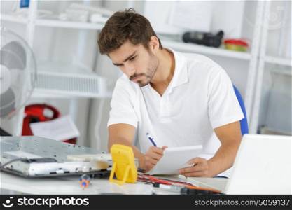 young engineer taking notes while developping new induction hobs
