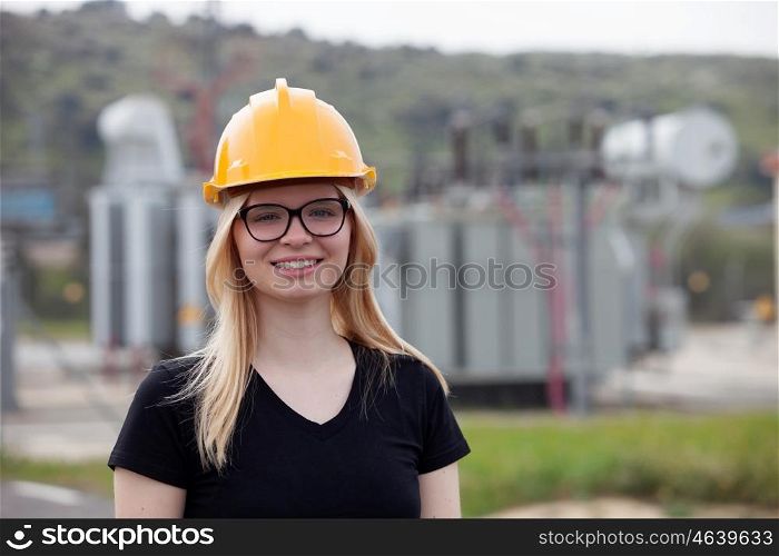 Young engineer with yellow helmet near his workplace