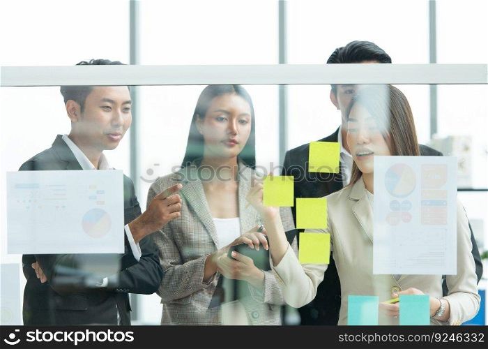Young entrepreneurs in Asia Organize meetings to brainstorm and review information on glass board to get the best investment conclusion
