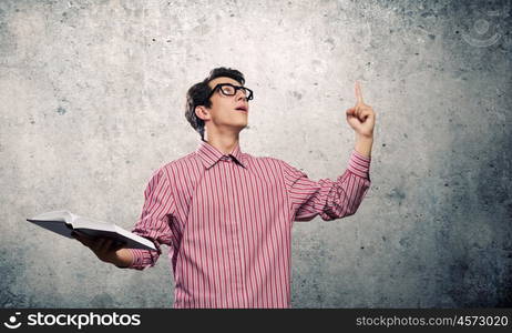 Young erudite. Young man in casual with book in hands